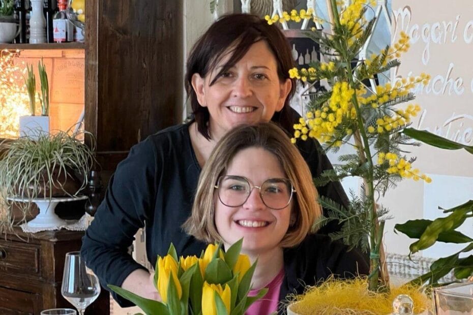 donne e vino fotografia di mamma e figlia in primo piano con fiori di mimosa